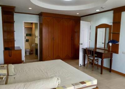 Spacious bedroom with wooden wardrobe and vanity