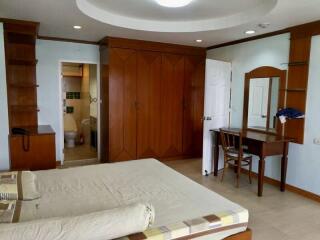 Spacious bedroom with wooden wardrobe and vanity