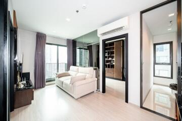 Modern living room with large windows, balcony access, and contemporary furniture