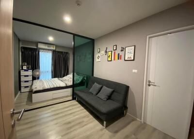 Modern bedroom with bed, sofa, and framed pictures