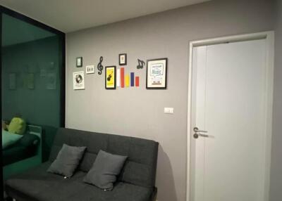 Modern living room with wall art, sofa bed, and closed door