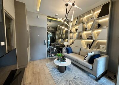 Modern living room with a sofa, decorative shelving, and contemporary lighting