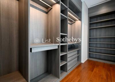 Spacious walk-in closet with wooden shelves and drawers