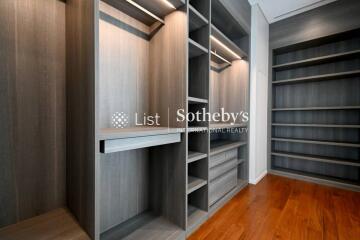 Spacious walk-in closet with wooden shelves and drawers