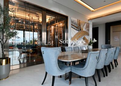 Modern dining room with large table, blue upholstered chairs, and sophisticated decor