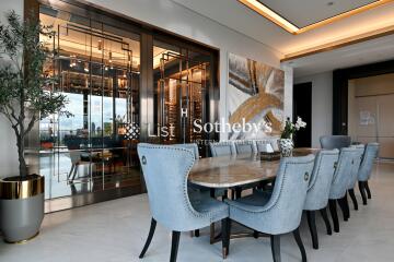 Modern dining room with large table, blue upholstered chairs, and sophisticated decor