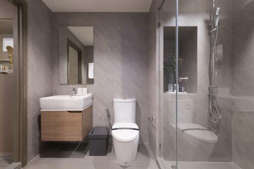 Modern bathroom with a glass shower, toilet, and sink with a mirror