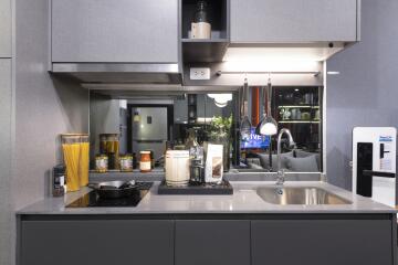 Modern kitchen with grey cabinets and countertop, sink, and stove