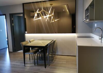 Modern dining area with contemporary lighting and adjacent kitchen