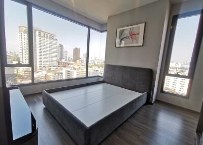 Spacious bedroom with large windows and city views