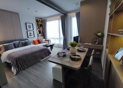 Modern studio apartment with bed, dining area, and living space