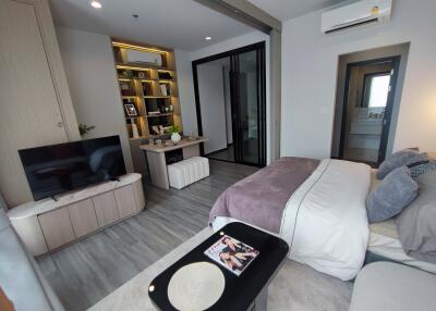 Modern bedroom with shelf, TV, and study desk