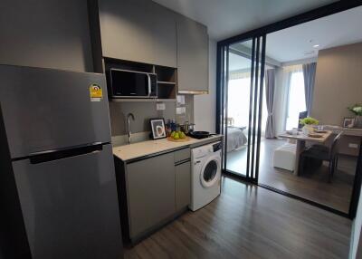 Compact kitchen with appliances, leading into a bedroom