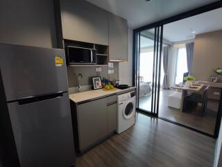 Compact kitchen with appliances, leading into a bedroom