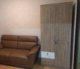 Living room with brown leather sofa and wooden wardrobe