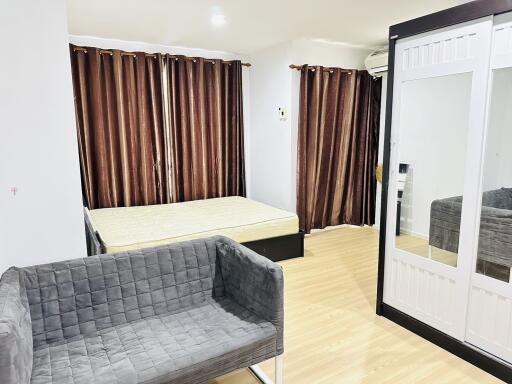 Spacious bedroom with bed, sofa, mirrored wardrobe, and hardwood floor