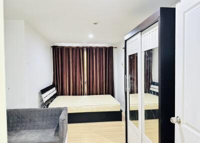 Spacious bedroom with large bed, wardrobe with mirrors, and sofa