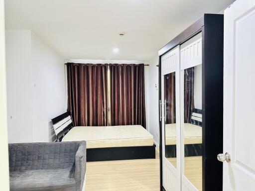 Spacious bedroom with large bed, wardrobe with mirrors, and sofa