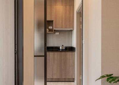 Modern narrow kitchen with wooden cabinets and black countertops