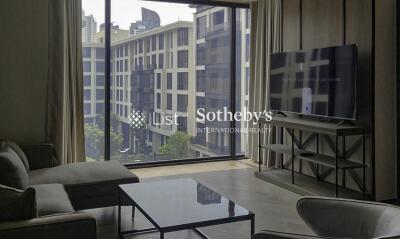 Modern living room with large window, office buildings view, and a wall-mounted TV