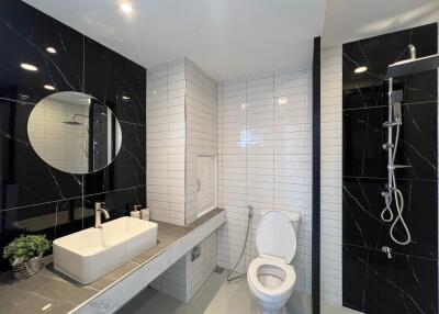 Modern bathroom with sink, toilet, and shower