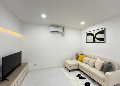 Modern and cozy living room with sectional sofa and wall-mounted TV