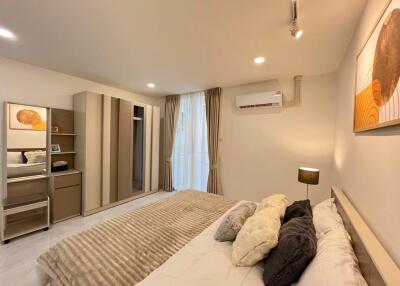 Spacious modern bedroom with double bed, air conditioning, and ample storage