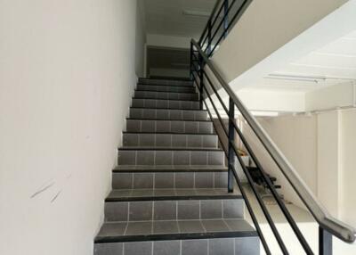 Staircase with black tiled steps and metal handrails