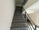 Staircase with black tiled steps and metal handrails