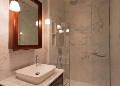 Modern bathroom with glass shower and marble walls