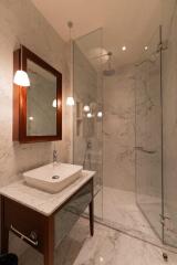 Modern bathroom with glass shower and marble walls