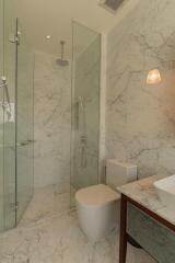 modern bathroom with glass shower and marble tiles