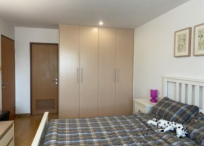 Cozy bedroom with wooden wardrobe and plaid bedding