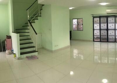 Spacious living room with tiled floors and a staircase