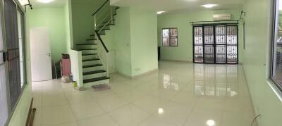 Spacious living room with tiled floors and a staircase