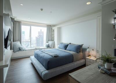 Modern bedroom with city view and blue bedding