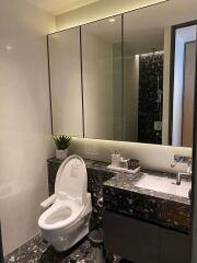 Modern bathroom with black marble countertops and a large mirror