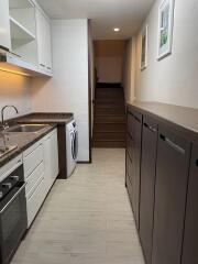 Modern kitchen with appliances and adjacent stairway