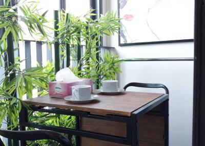 Cozy balcony seating area with a small table and chairs, adorned with plants and artwork