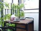 Cozy balcony seating area with a small table and chairs, adorned with plants and artwork