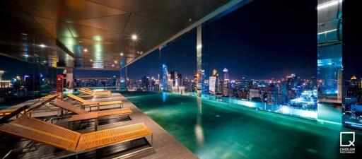 Rooftop swimming pool with city skyline view at night