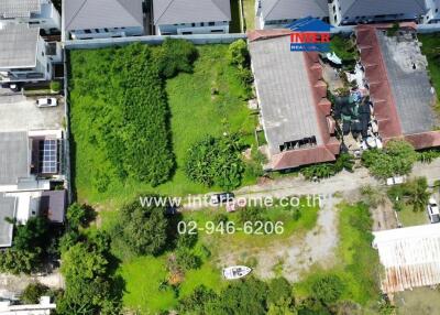 Aerial view of a neighborhood with a mix of houses, lawns, and undeveloped land