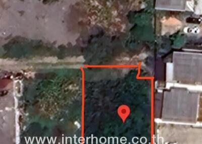 Aerial view of a land plot highlighted in red in a residential area