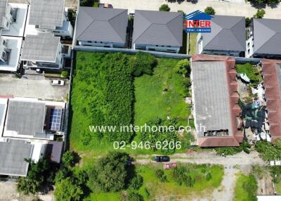 Aerial view of property including buildings and vacant lot