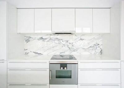 Modern kitchen with white cabinetry and marble backsplash