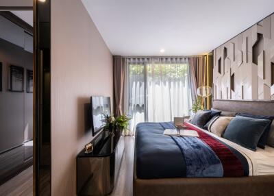 Modern bedroom with large bed, TV, and floor-to-ceiling window