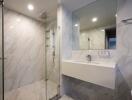 Modern bathroom with glass shower and wall-mounted sink