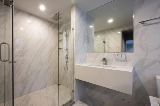 Modern bathroom with glass shower and wall-mounted sink