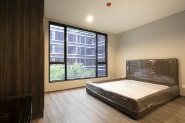 Spacious bedroom with large windows and a new bed