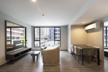 Modern living room with large windows and dining area